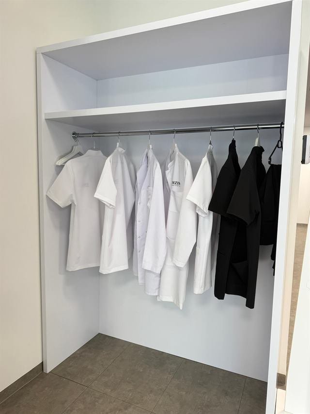 Schrank mit frischen Kitteln und Arbeitskleidung